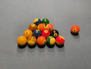 Eine beispielhafte Situation beim Wiederaufbau der Kugeln. 14 Objektkugeln wurden als Dreieck ohne die vorderste Kugel aufgebaut, die 15. Kugel liegt neben dem Dreieck.